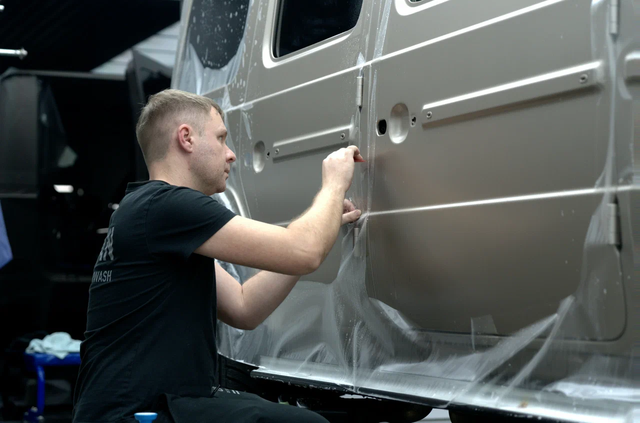 Мастер Urban Detailing укладывает полиуретановую плёнку на кузов автомобиля